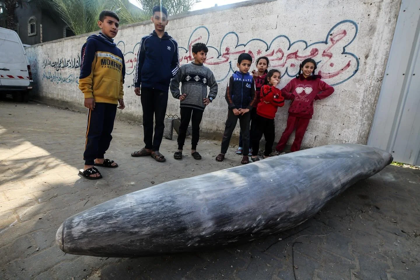 Gaza children standing near unexploded bomb