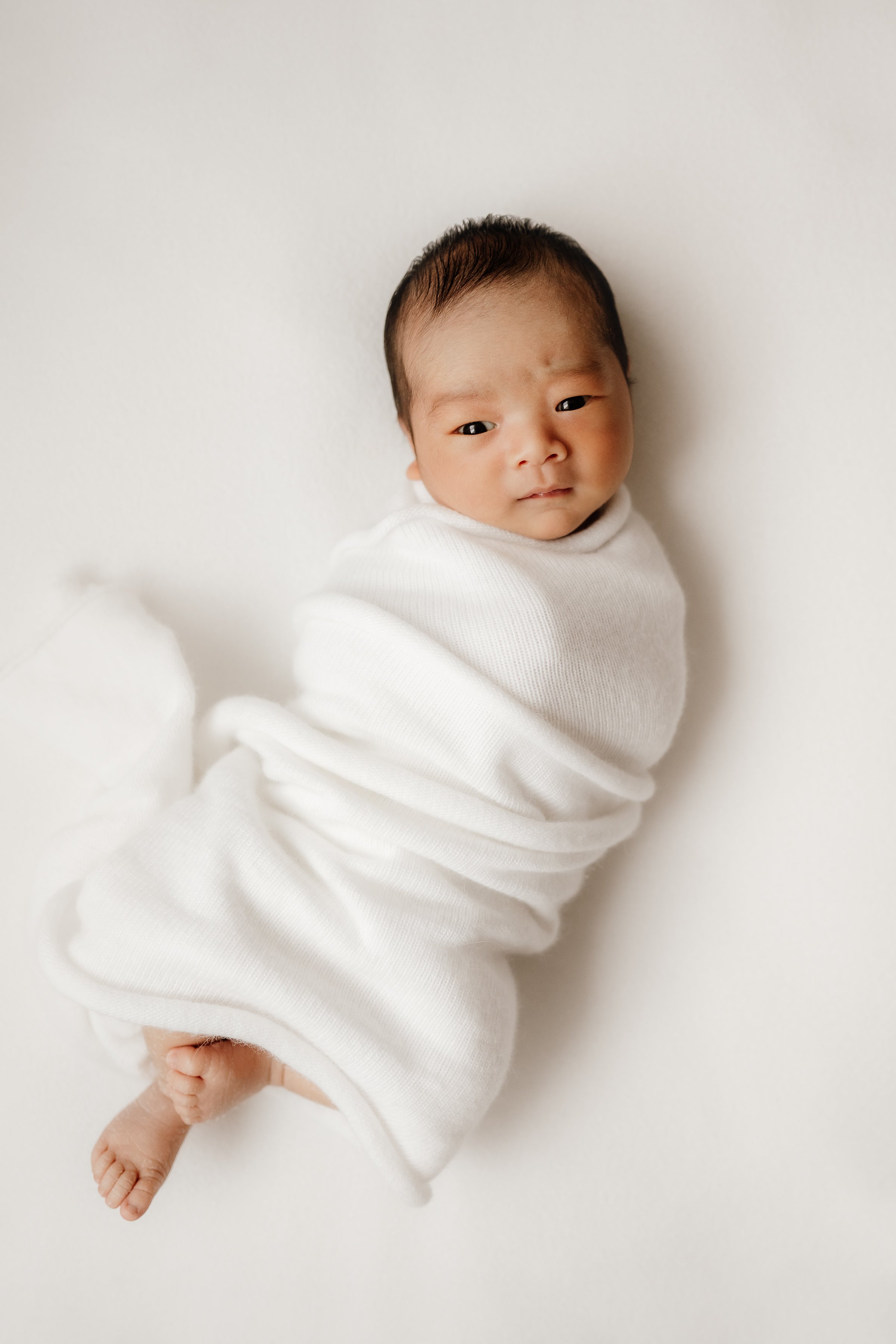 Peaceful newborn resting in a cozy neutral pose.JPG