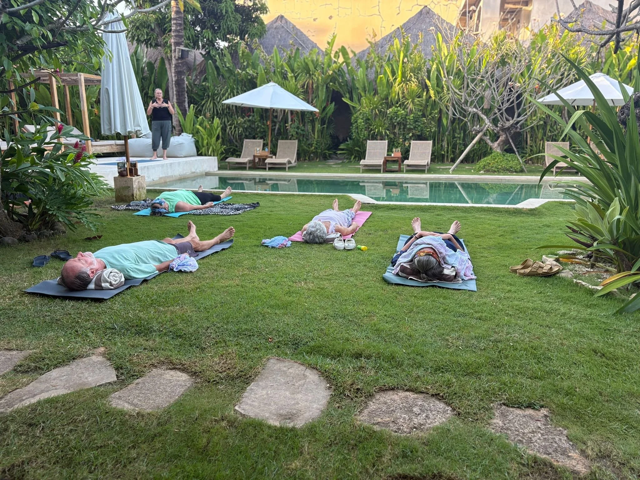 POOLSIDE YOGA STUDENTS IN SAVASANA