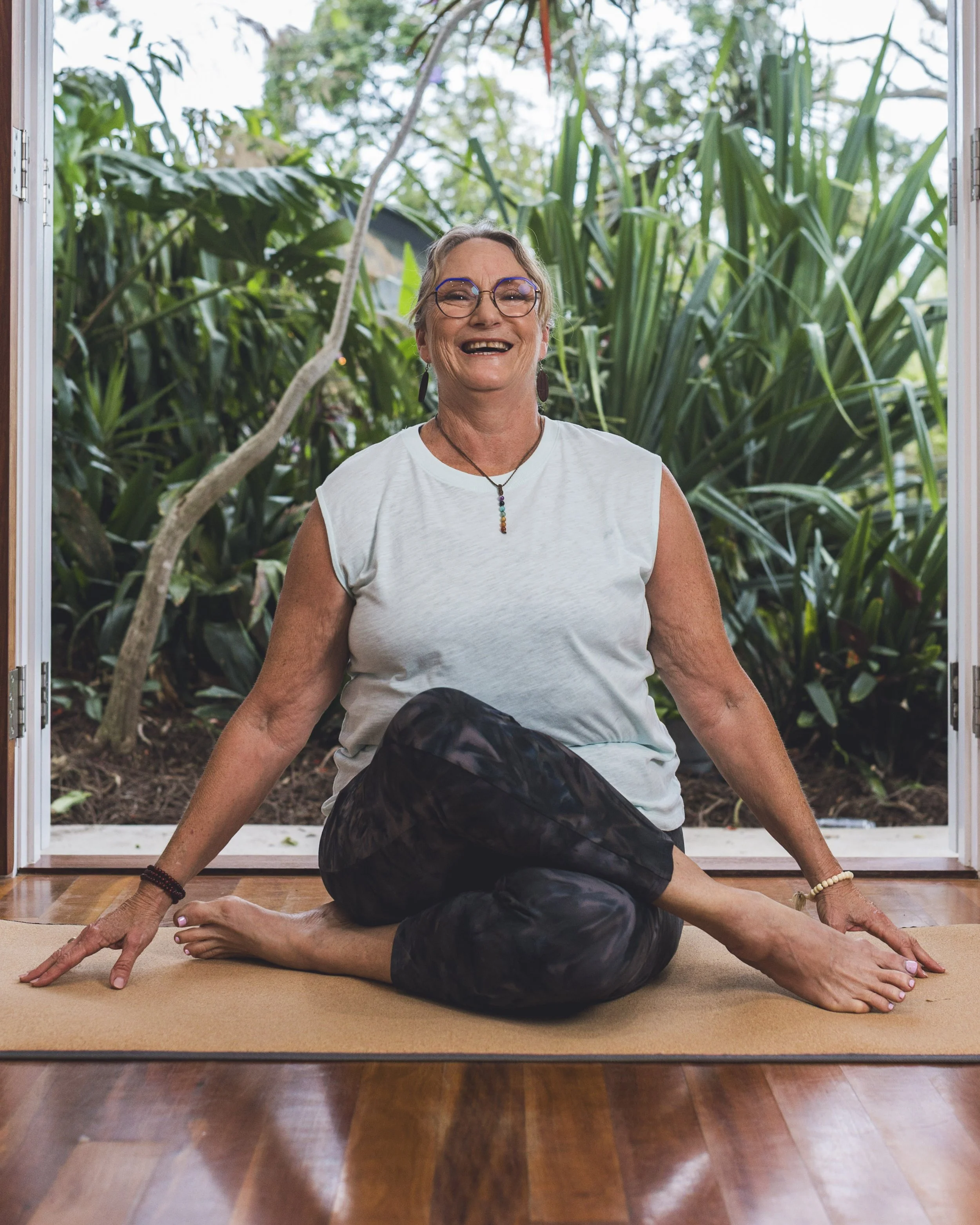 Shannon sitting on a yoga mat smiling