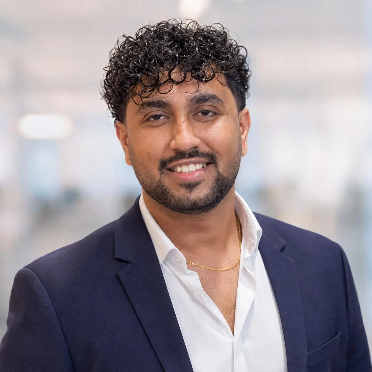 Kevin Mistry, co-founder of MyCo, smiling in a navy blazer and white shirt.