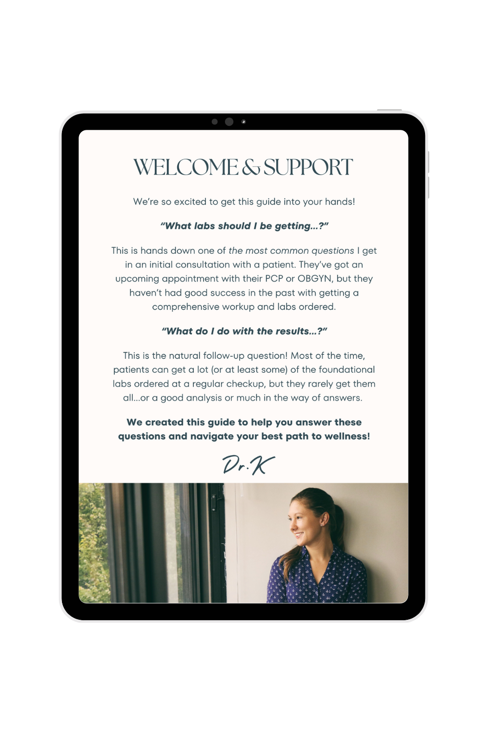 A digital screen displays a welcome message and guide about lab results and wellness, with a photo of a smiling woman sitting by a window at the bottom.