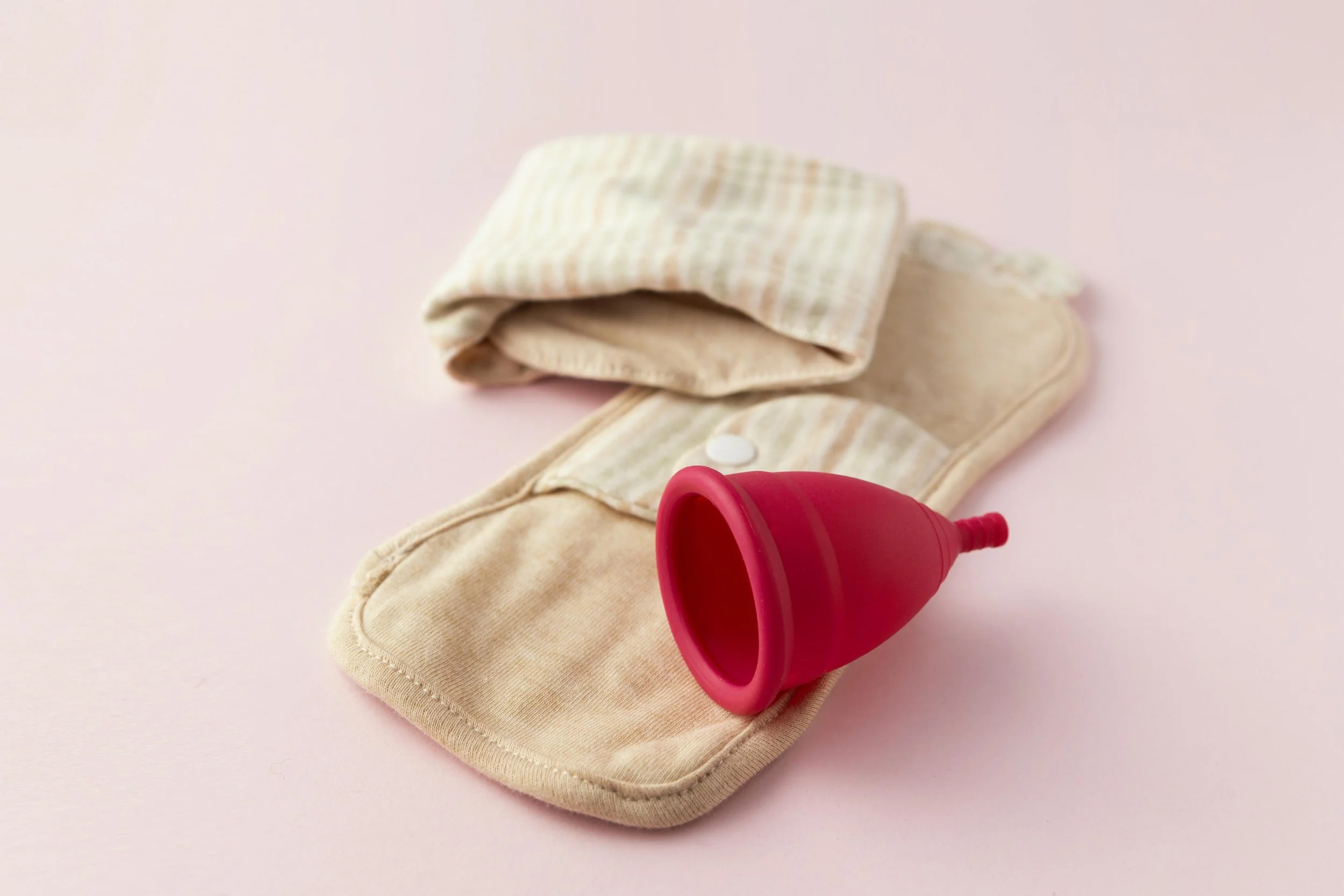 pink menstrual cup and cotton pad period