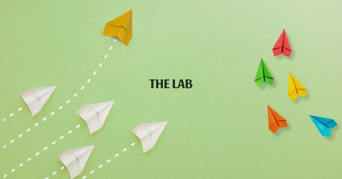 Colorful paper airplanes on a light green background with the text 'The Lab' in the center.