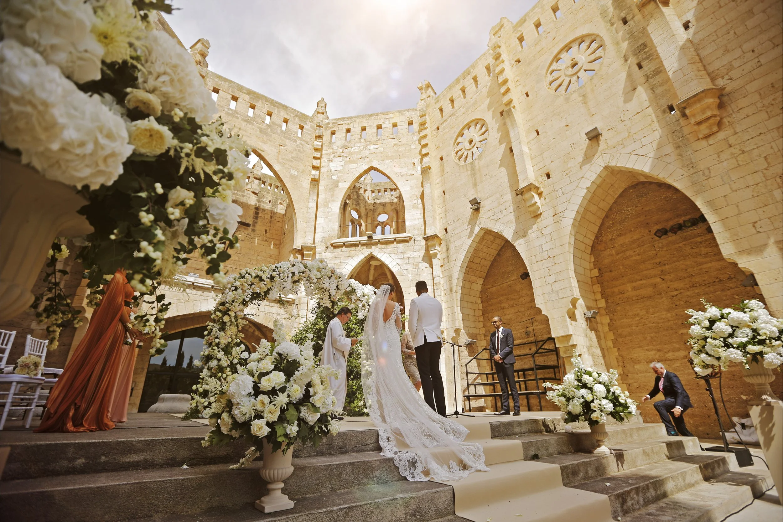 Wedding ceremony in a historic building courtyard with floral decorations