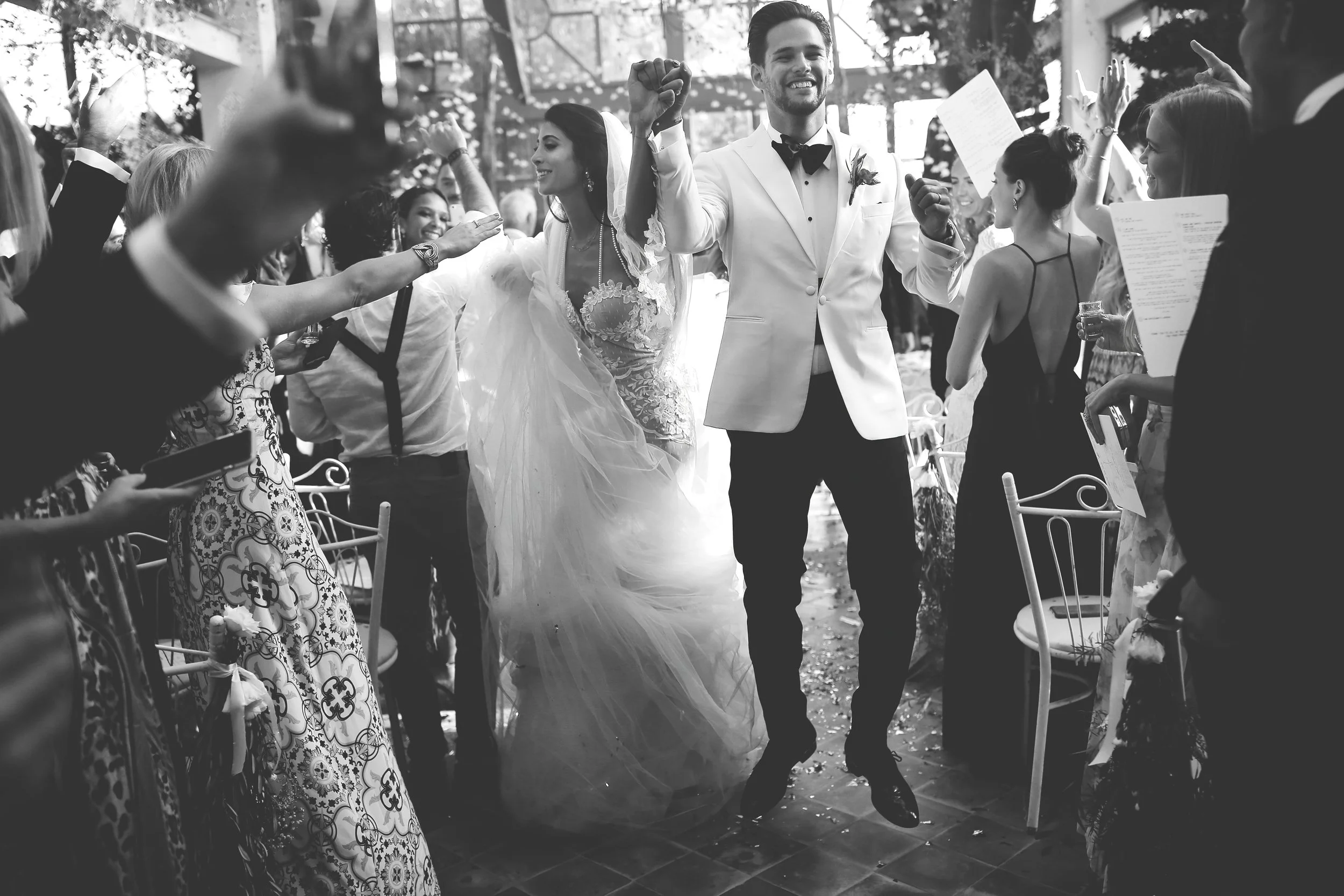 Bride and groom celebrating with guests at a wedding ceremony.