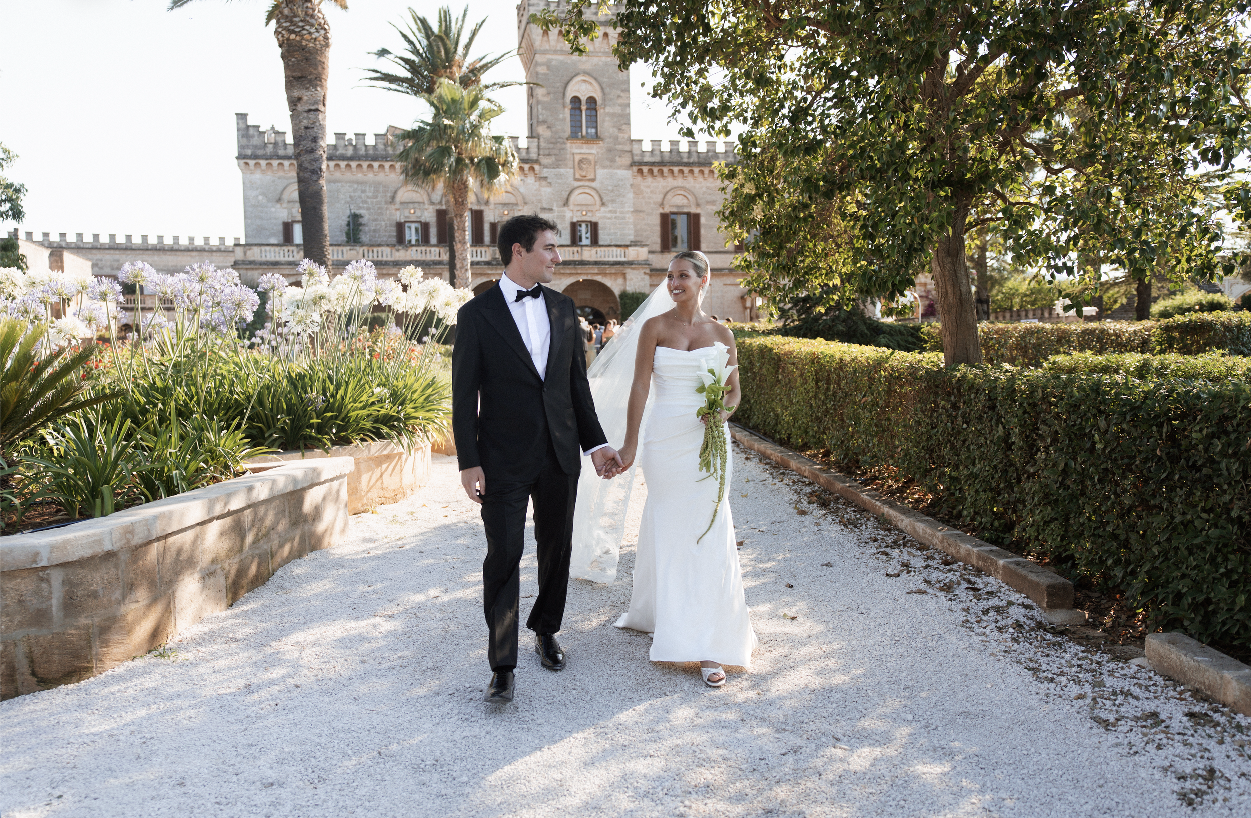 Bride and groom walking through the gardens at a Puglia wedding in Italy