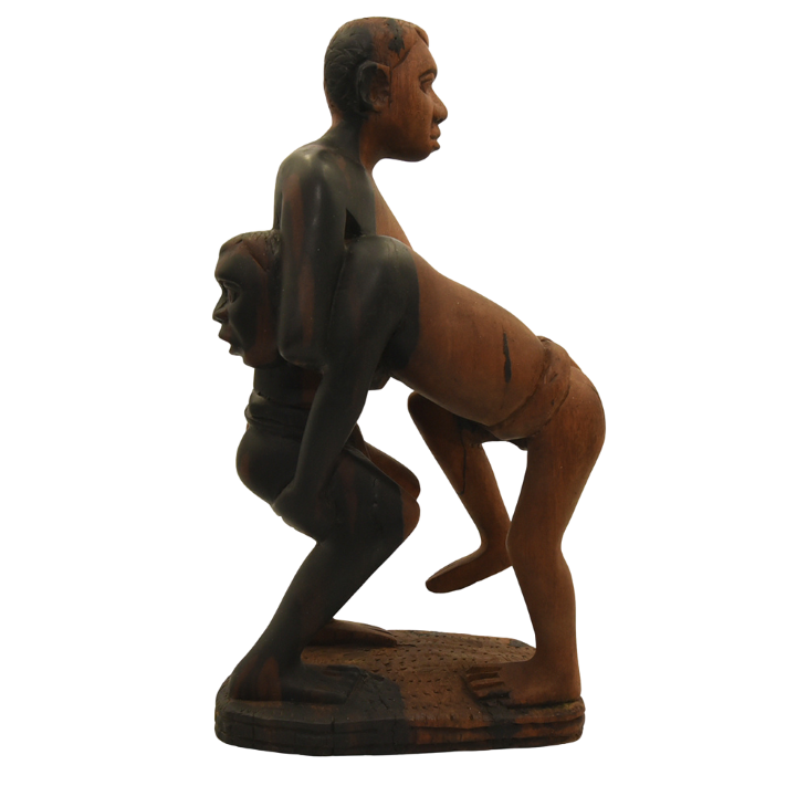 Hardwood sculpture of two Senegalese wrestlers grappling.