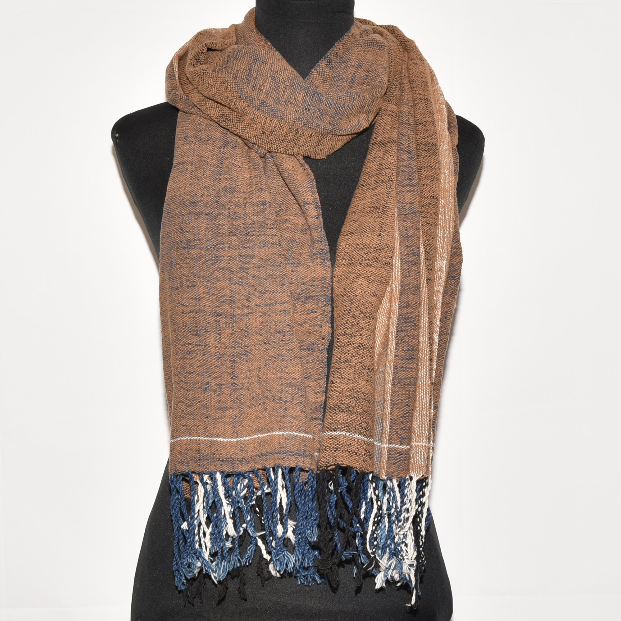 Hand-spun, hand-dyed, and hand-woven shawl made from thick organic cotton, featuring stripes in brown, tan, indigo, black, and white, with tassels at both ends. The shawl measures 2m x 70cm.