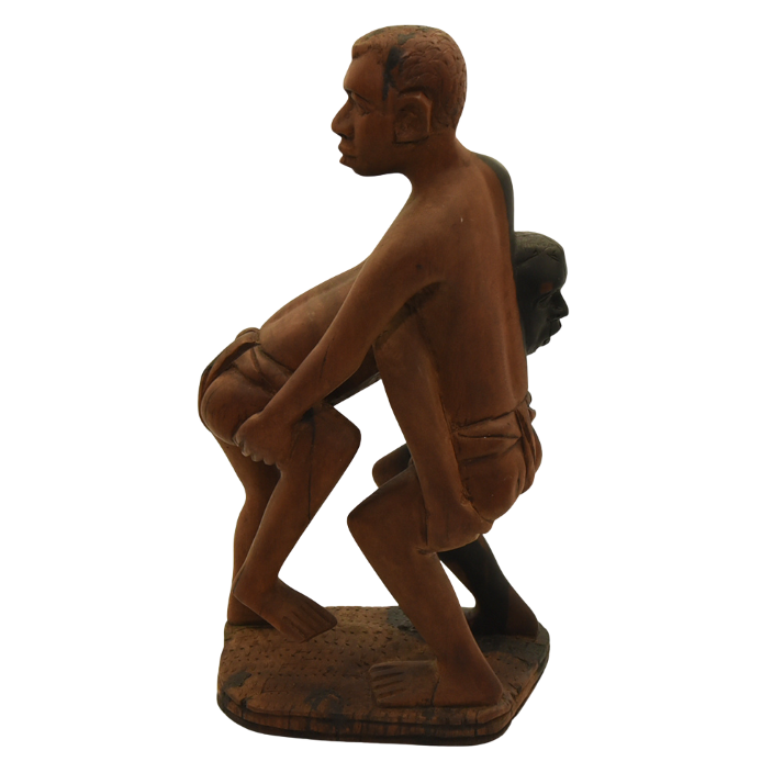 Hardwood sculpture of two Senegalese wrestlers grappling.