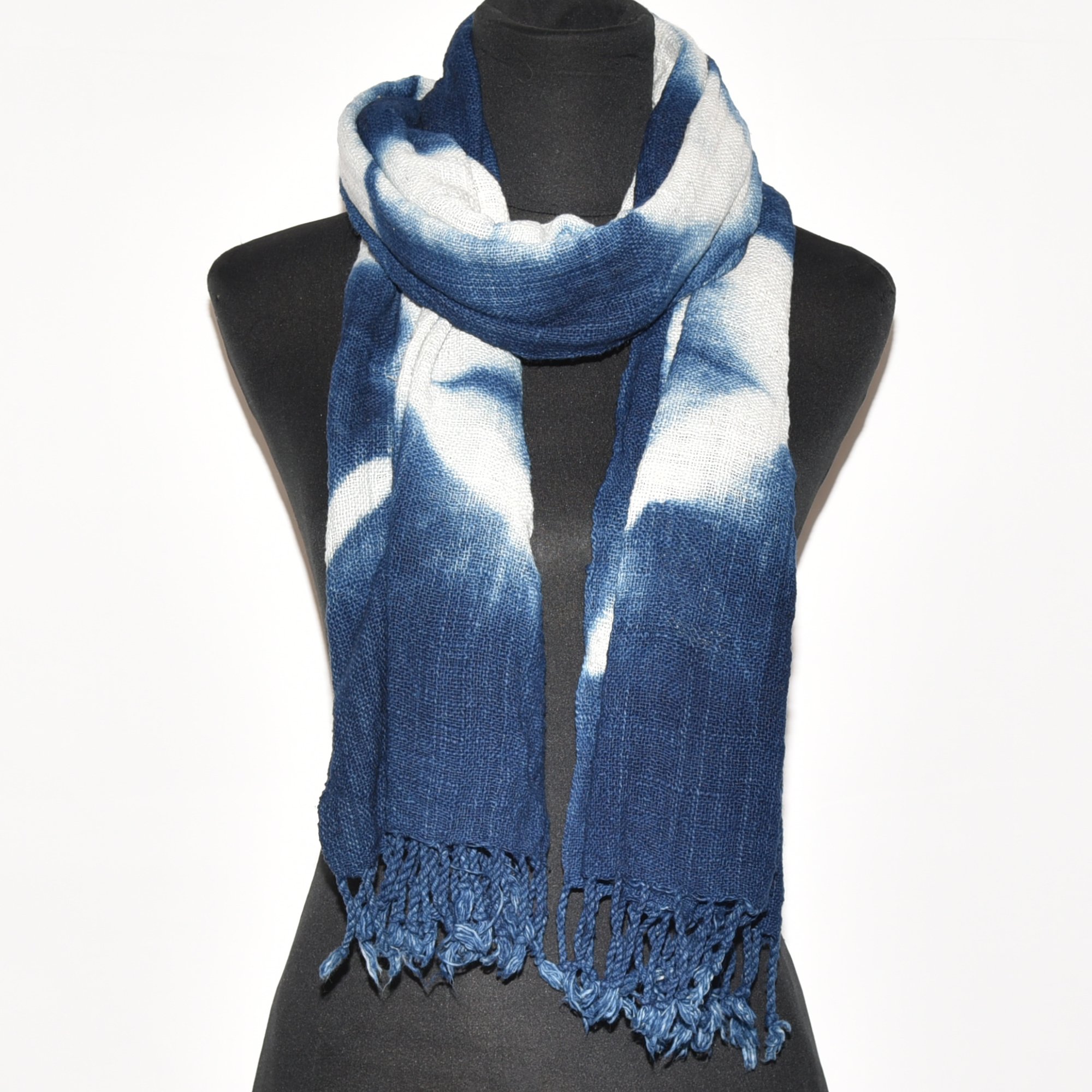 Handspun, hand-dyed, and hand-woven indigo and white tie-dyed shawl made from thick organic cotton with tassels. Measures 2 meters by 70 centimeters.