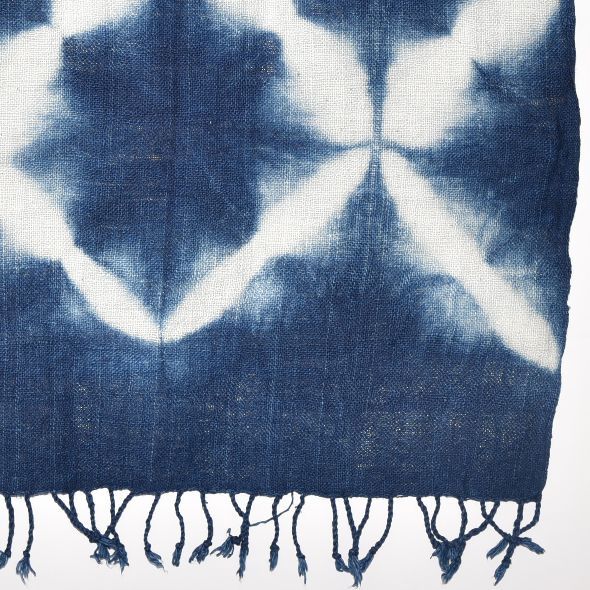 Handspun, hand-dyed, and hand-woven indigo and white tie-dyed shawl made from thick organic cotton with tassels. Measures 2 meters by 70 centimeters.