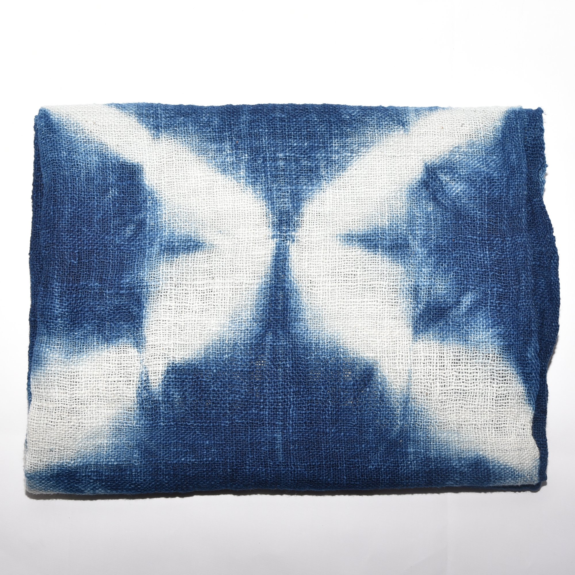 Handspun, hand-dyed, and hand-woven indigo and white tie-dyed shawl made from thick organic cotton with tassels. Measures 2 meters by 70 centimeters.