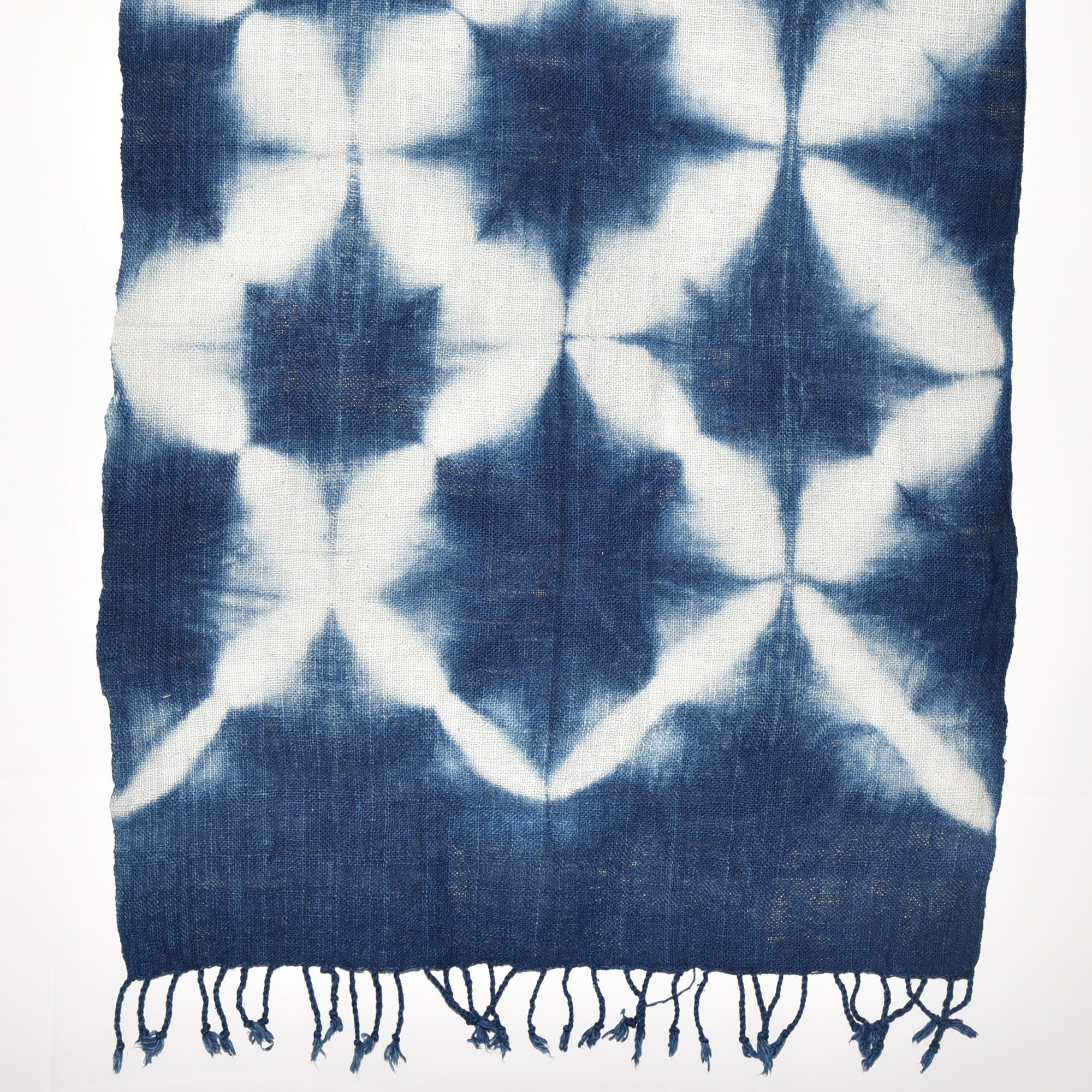 Handspun, hand-dyed, and hand-woven indigo and white tie-dyed shawl made from thick organic cotton with tassels. Measures 2 meters by 70 centimeters.