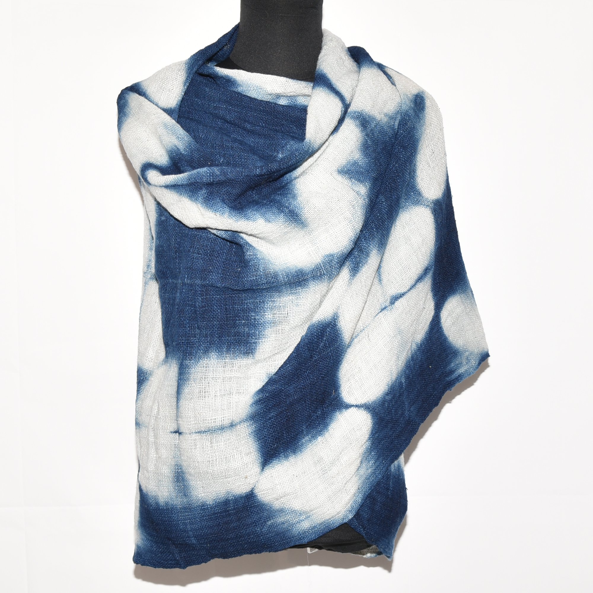 Handspun, hand-dyed, and hand-woven indigo and white tie-dyed shawl made from thick organic cotton with tassels. Measures 2 meters by 70 centimeters.