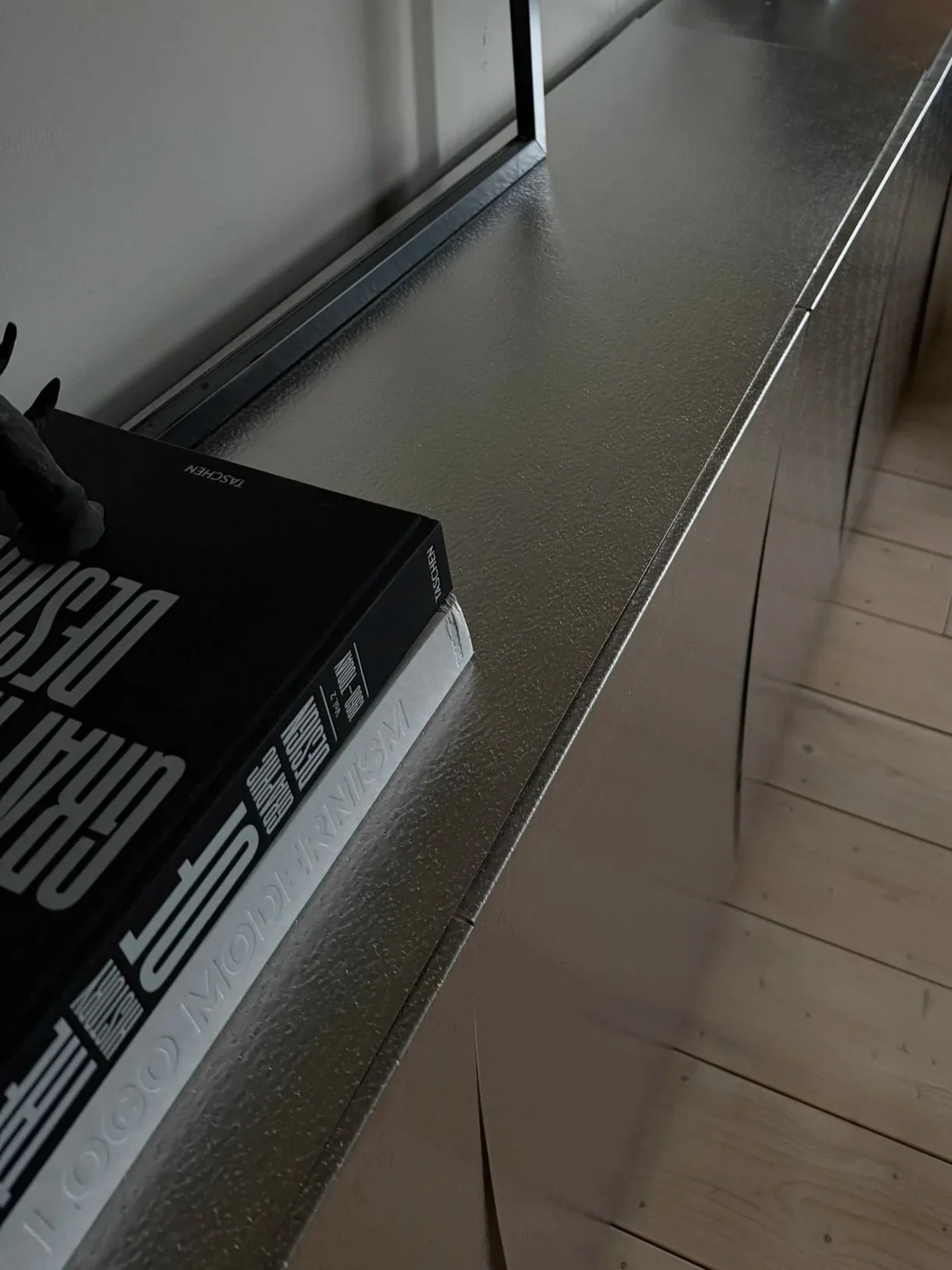 Ein Blick auf eine metallische Küchenarbeitsplatte mit einem schwarzen Bosch Backofen und einem Karton darauf.