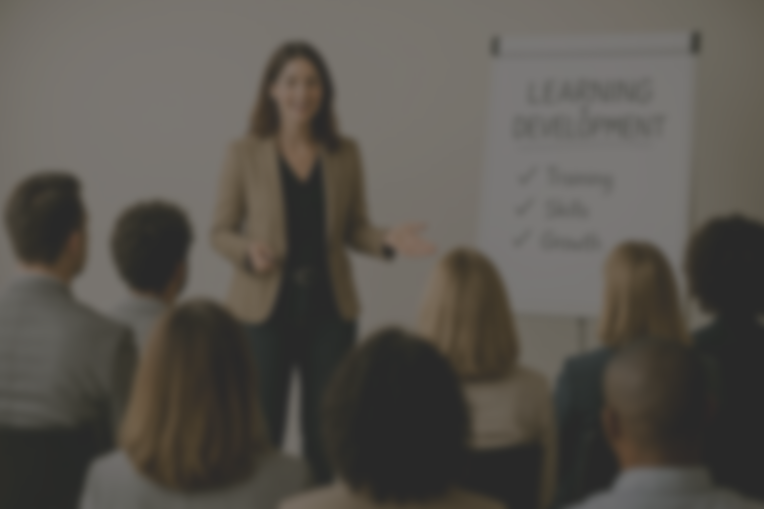 Vrouw geeft presentatie aan groep mensen met een whiteboard dat 'Learning Development' en componenten zoals 'Training', 'Skills', en 'Growth' toont.