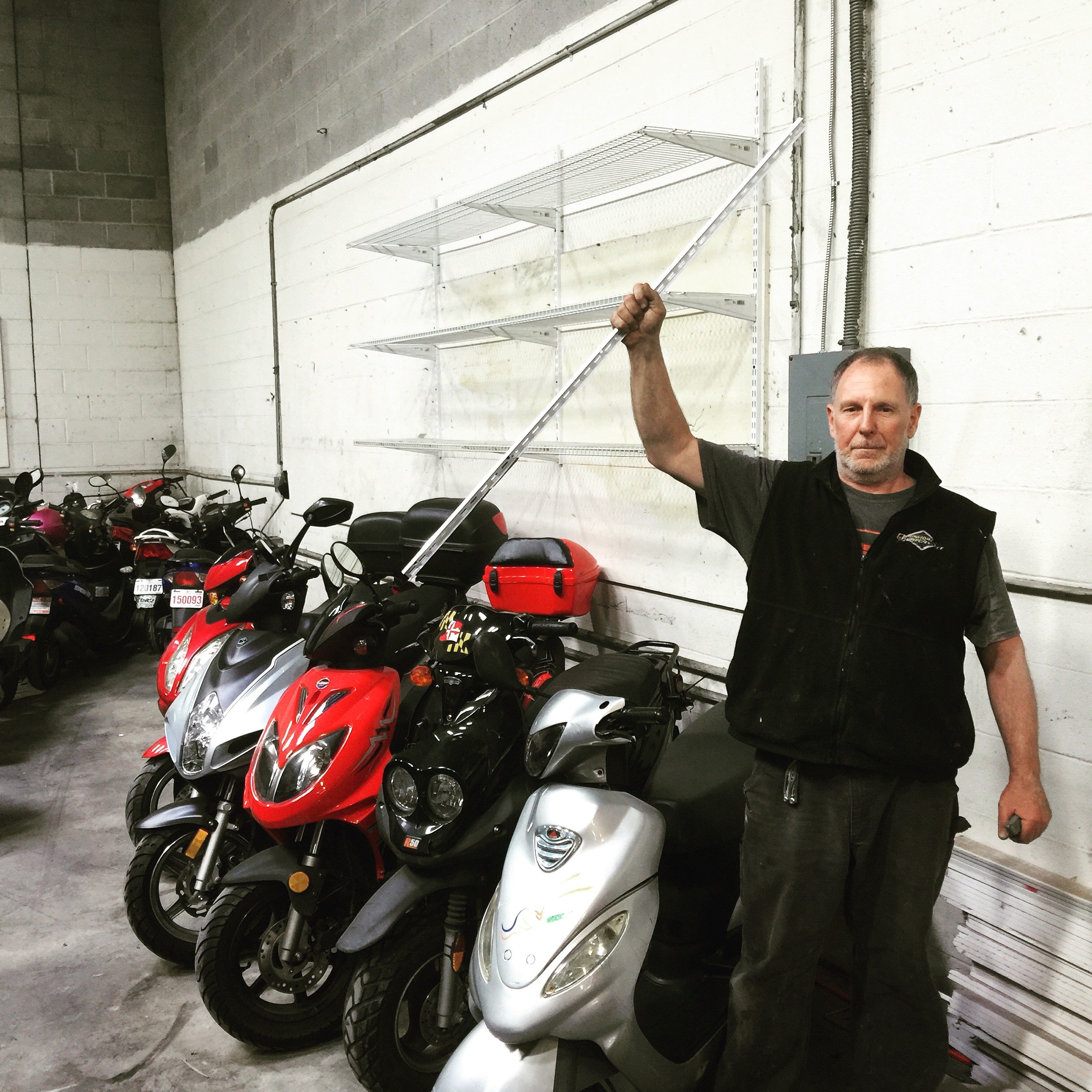 Hugh feeling accomplished after a day of hanging shelves into the concrete block