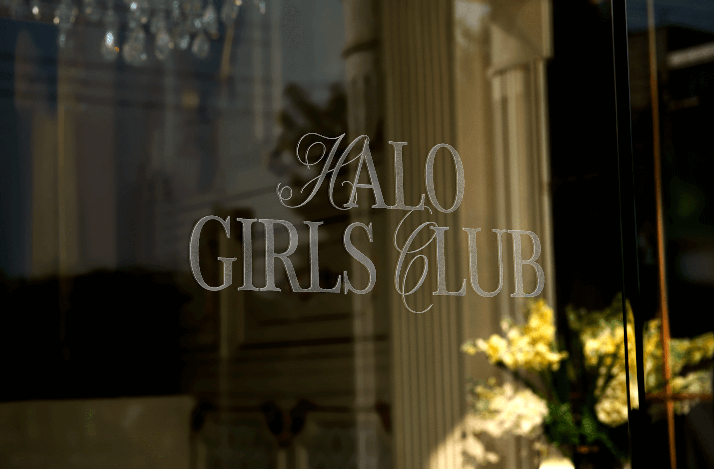 Une fenêtre de boutique avec une inscription en lettres argentées indiquant 'GIRLS CLUB'.