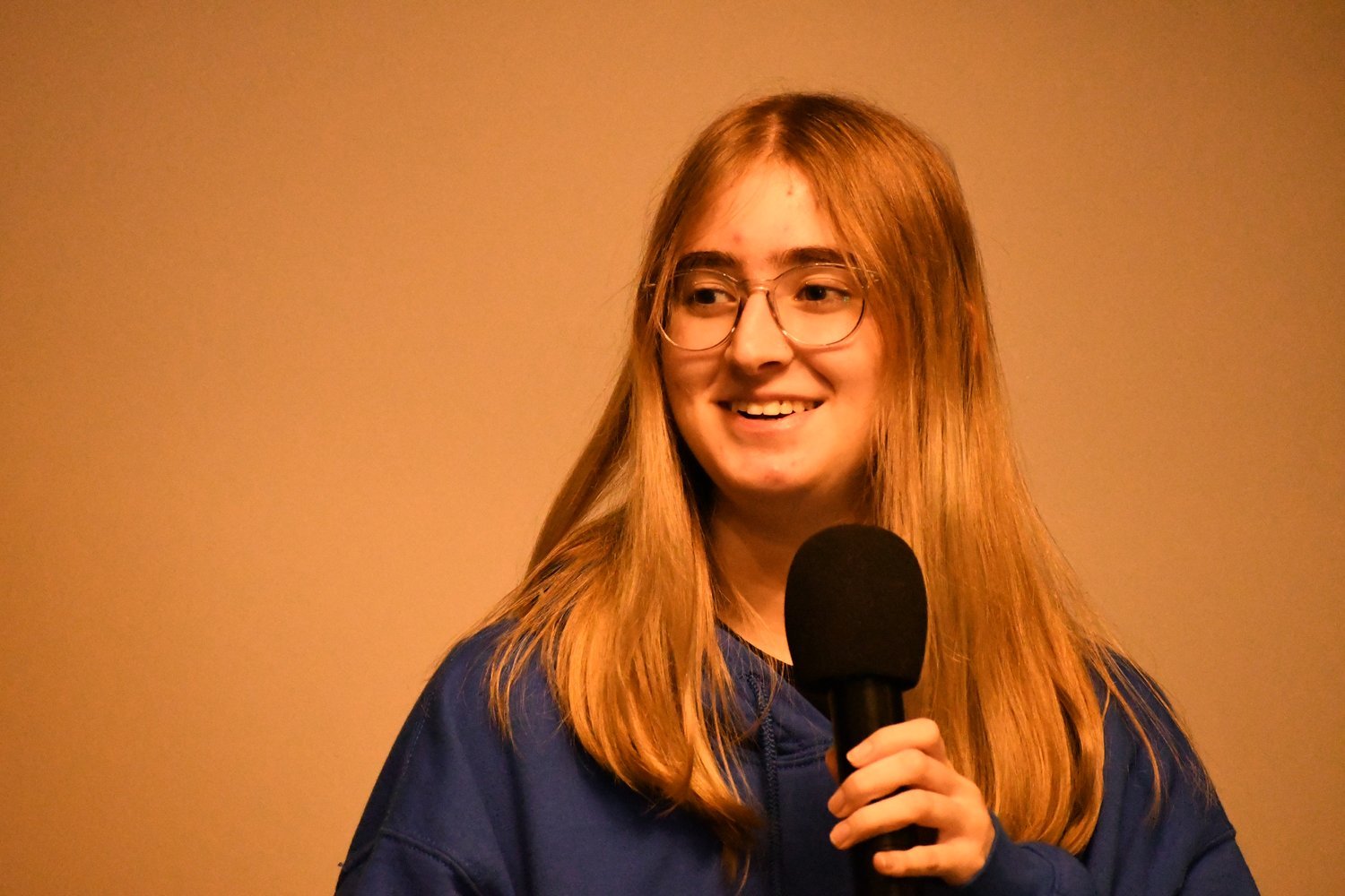 Junior Fellow Madelyn Tyler representing North Side High School examines the connections between hunger and poverty on stage at Monthly Meeting 5.