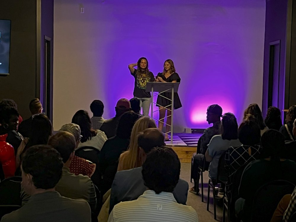 Kalin Earnest takes the microphone from emcee Lauren Pritchard (LOLO) to answer questions from community leaders on the topic of Assault and Harassment and the impacts on the Jackson Madison County community.