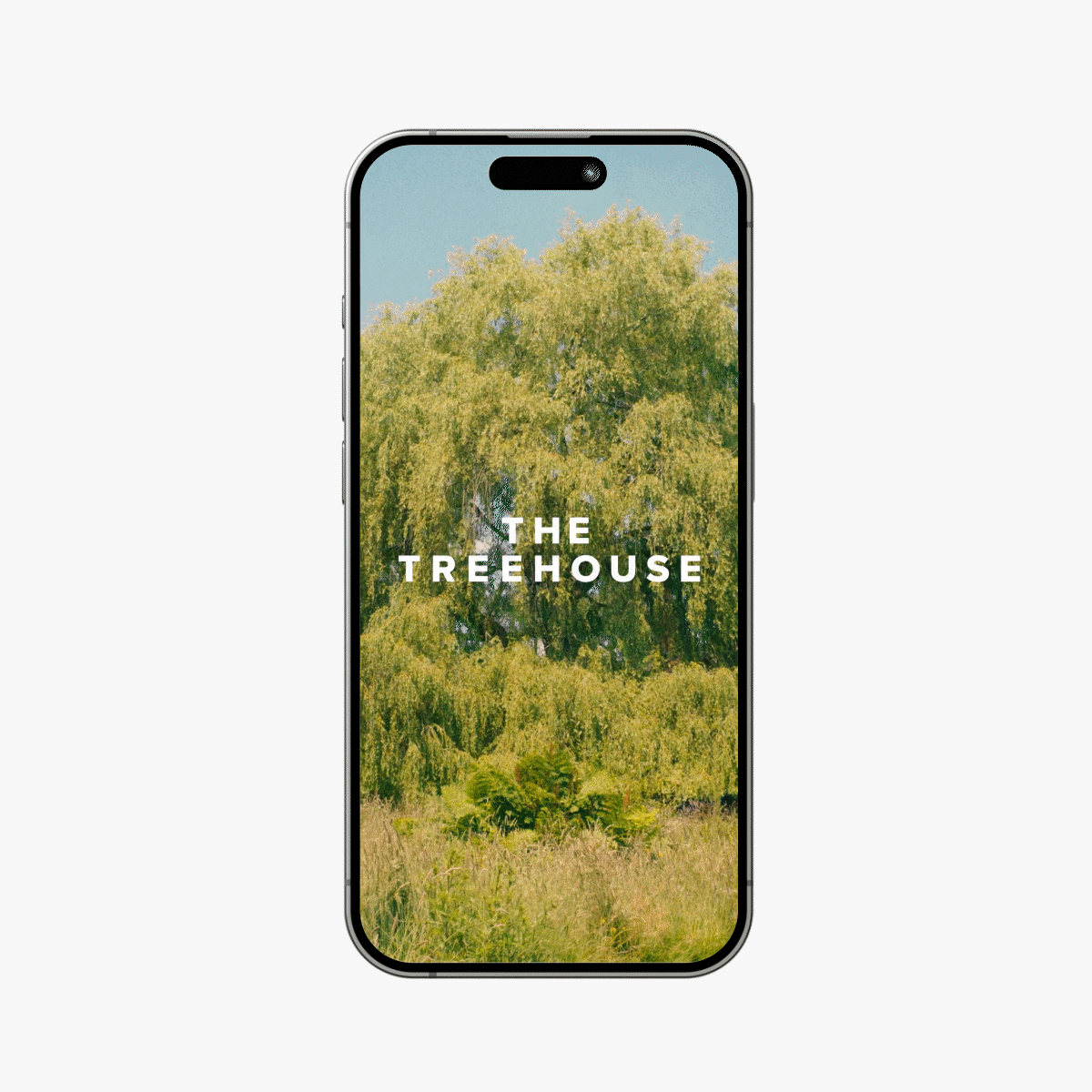 A smartphone displaying an image of a large green tree in a natural setting with the text "THE TREEHOUSE" overlaid on the image.