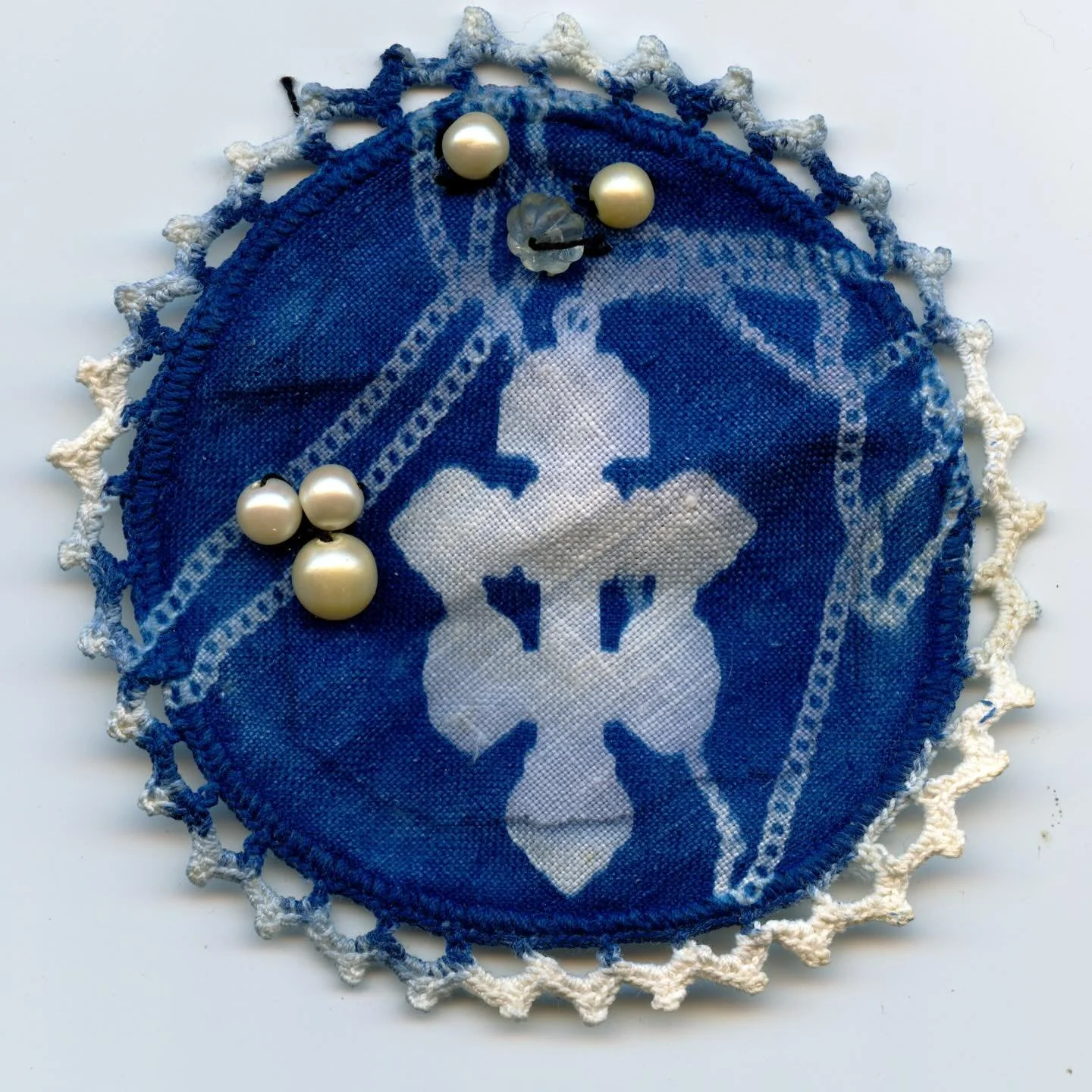 Crucifix &amp; Chain Cyanotype with hand sewn beads on a doily 
-
With a video of me working on this piece, shoutout to my grandmother for teaching me hand sewing all those years ago