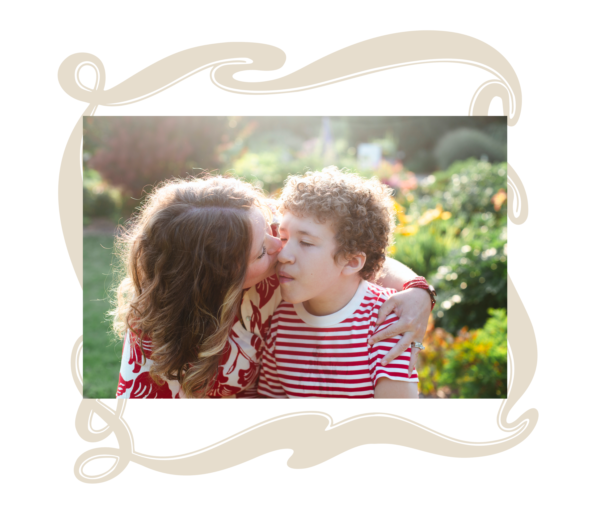 A mother and son embracing outdoors in a garden. The woman is kissing the boy on the cheek, and they are both smiling with their eyes closed. The background is sunlit with green and orange foliage.
