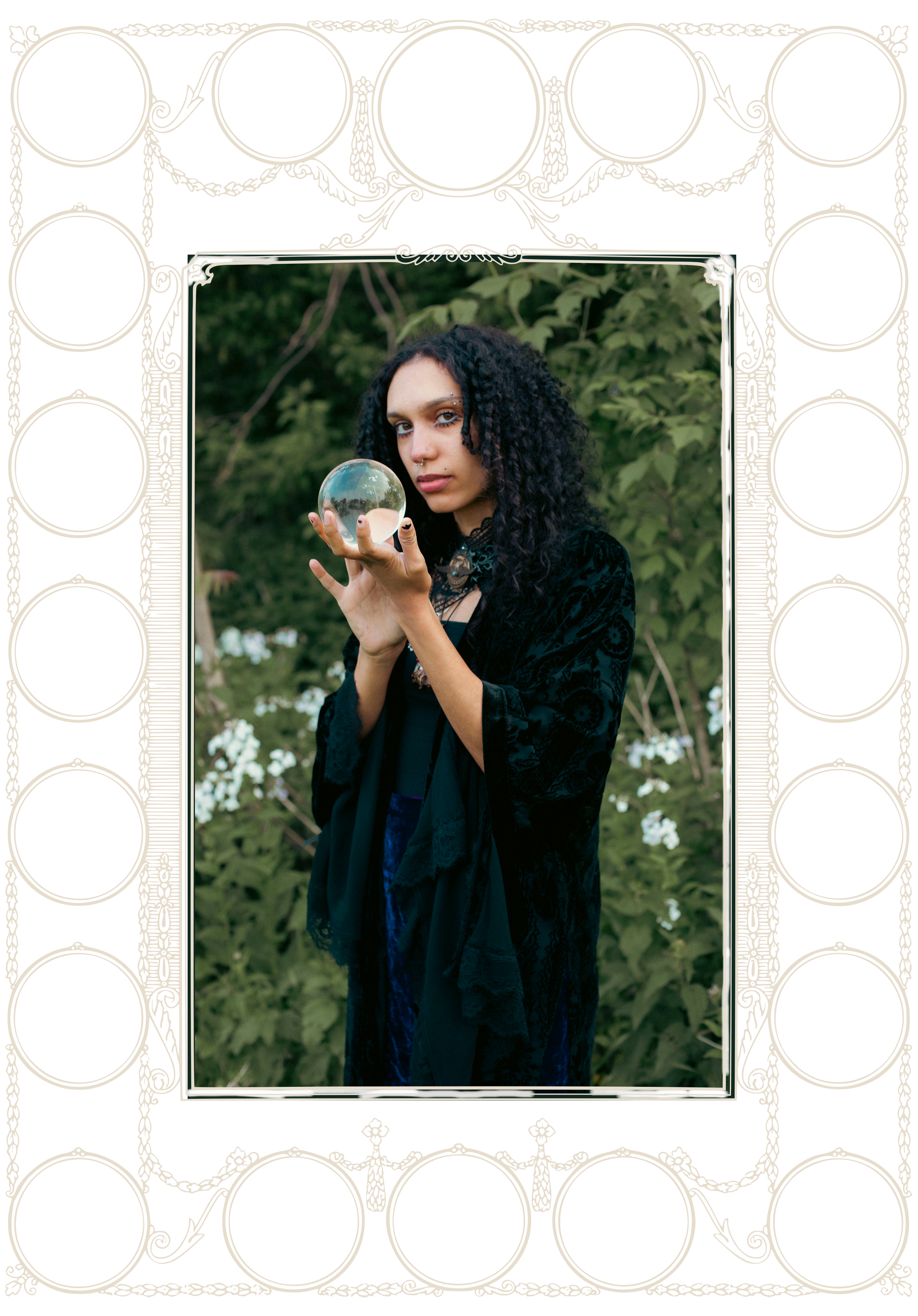 A woman with dark curly hair, wearing black lace clothing, holding a glass orb outdoors with green foliage in the background.
