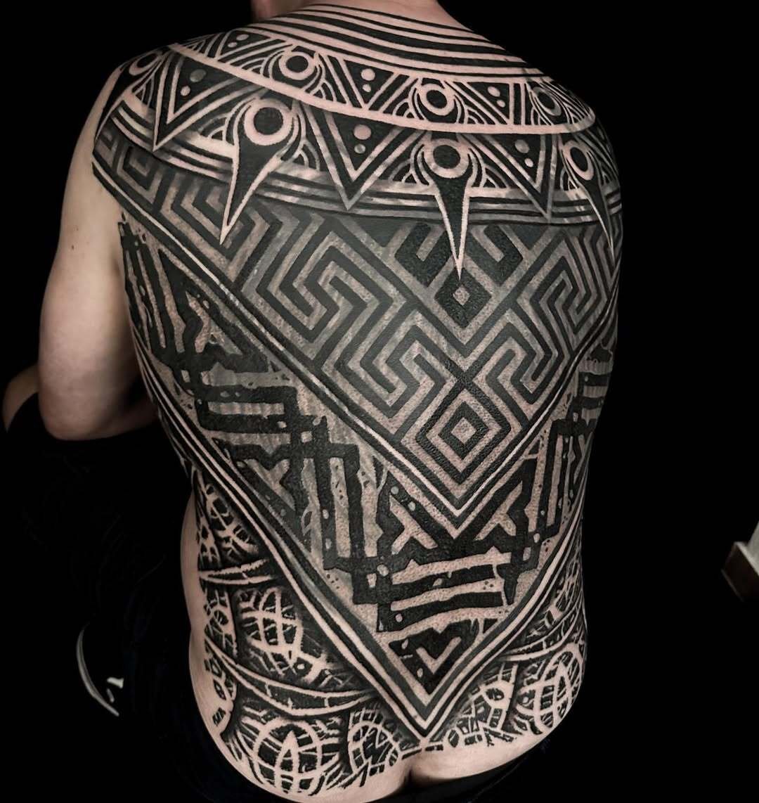 Intricate full back tattoo with geometric patterns in black ink