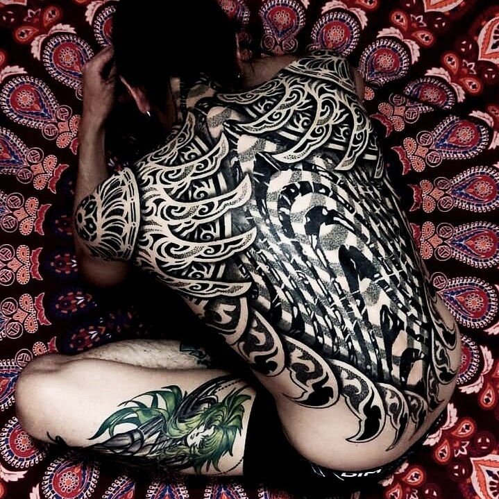 Full back geometric tattoo in Lisbon, Portugal – bold blackwork with sharp angles and symmetrical patterns.