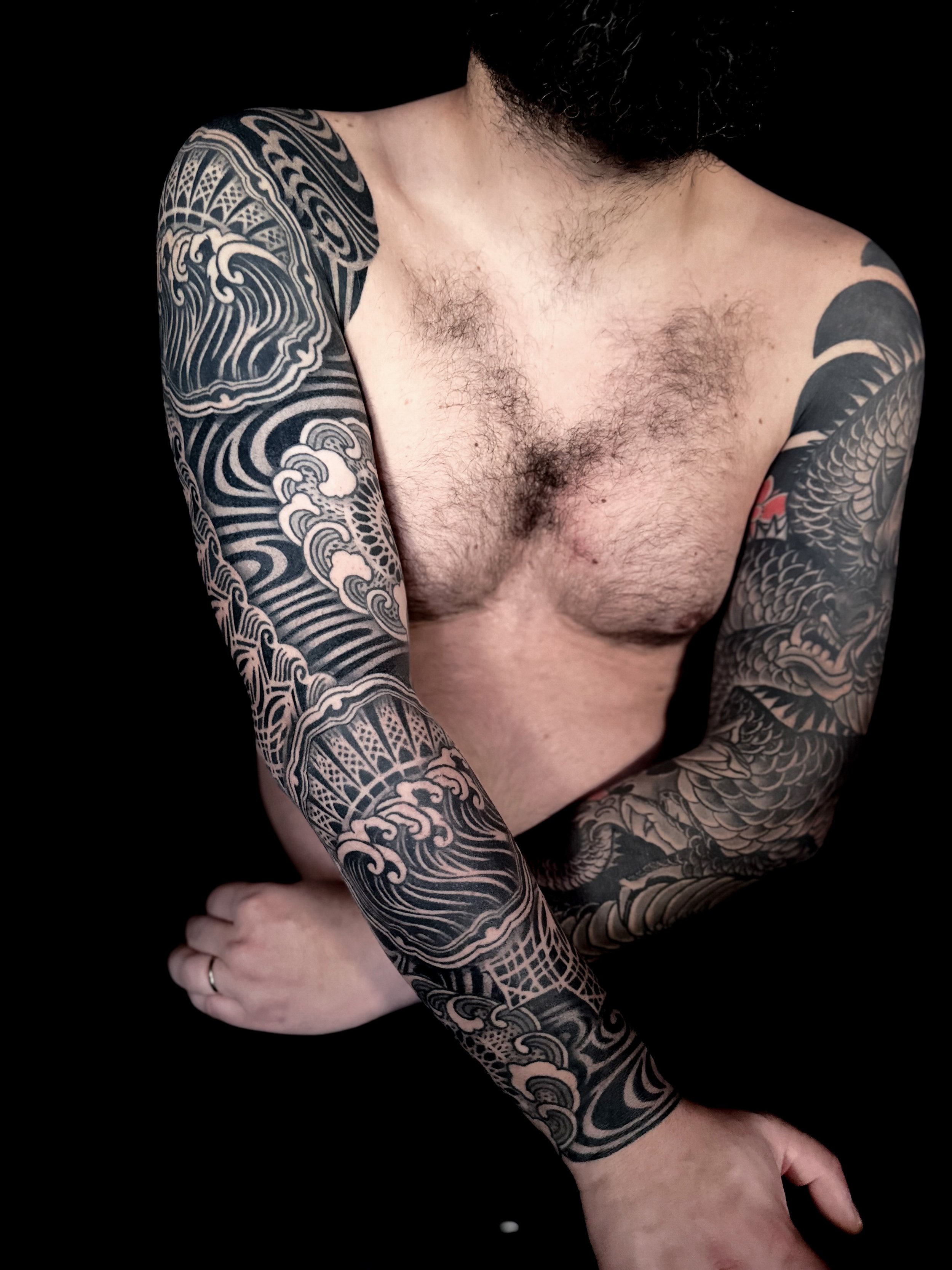 Japanese-style tattoos on both arms, featuring intricate wave designs. full sleve tattoo