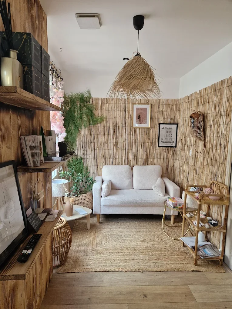 Un salon cosy avec un canapé blanc, des plantes vertes, des décorations en rotin, un tapis en fibre naturelle et une murale en bambou.