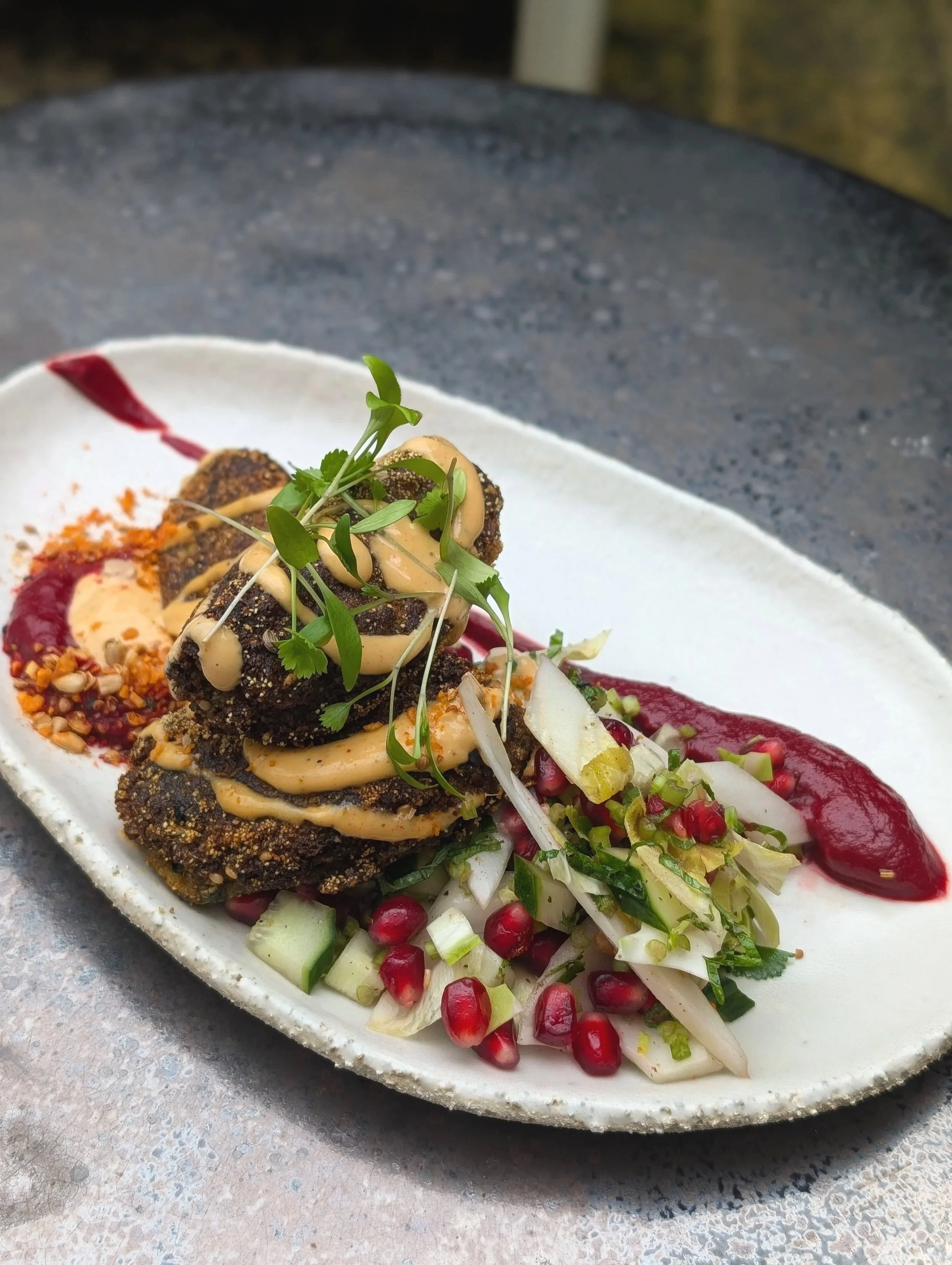 Vegan Cauliflower Falafel, Smashed Beetroot, Bitter Salad, Pomegranate, Tahini Garlic Drizzle