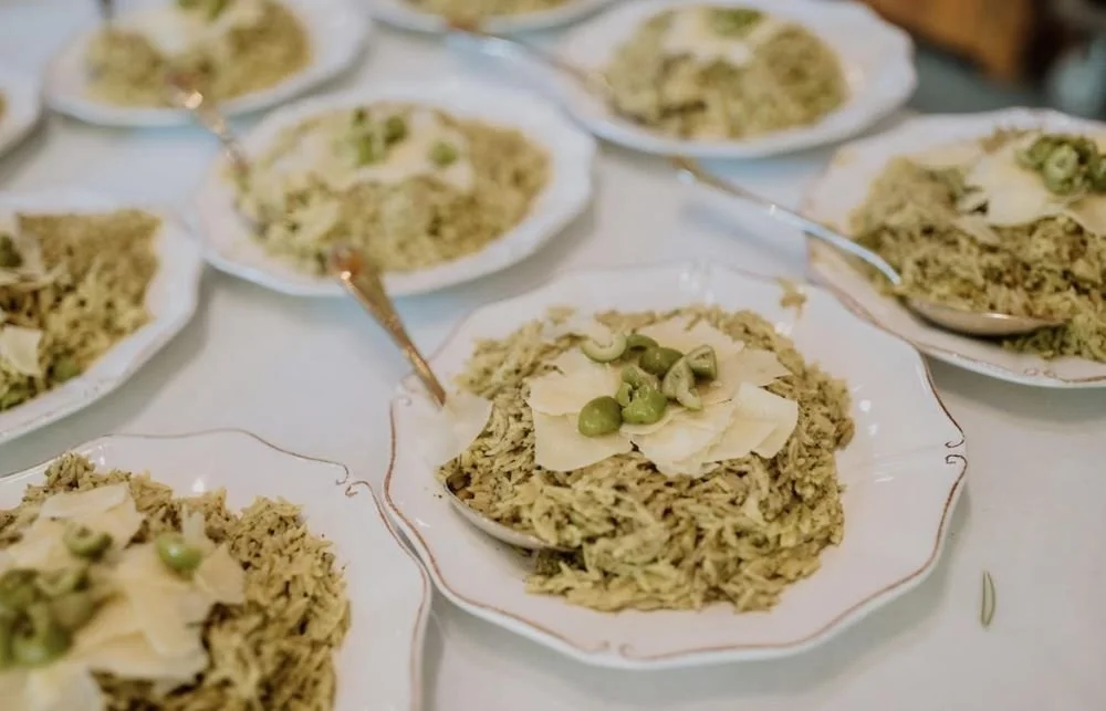 Dishes of chicken and rice garnished with sliced almonds and green peas