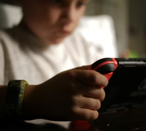 Boy on playing video games on a handheld device