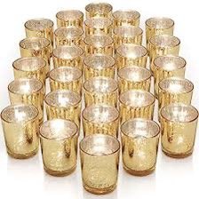 A group of gold-colored glass candle holders arranged in neat rows on a white background.