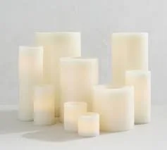 Assorted white pillar candles of varying heights.