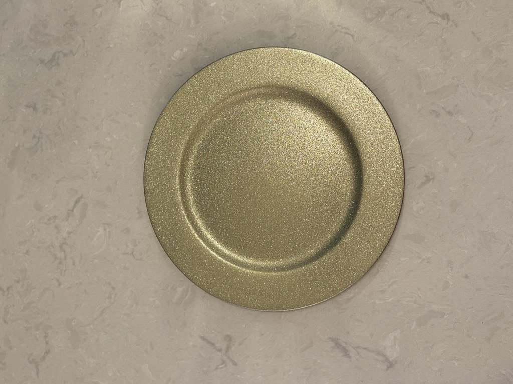 Gold metallic plate on a light marble surface