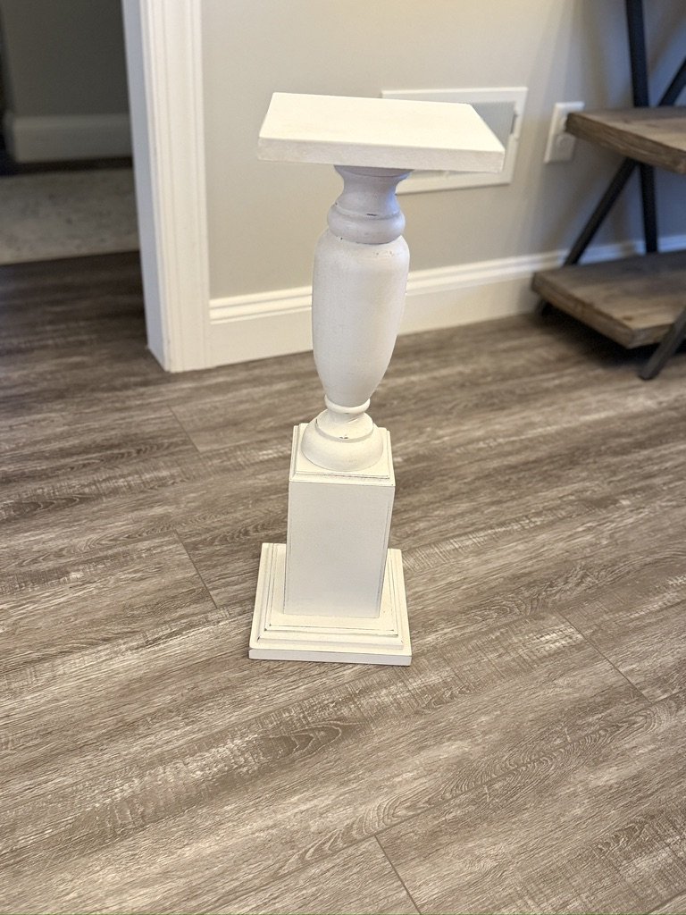 White wooden pedestal stand on wood floor