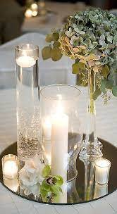 Elegant table centerpiece with candles, hydrangeas, and mirrored surface