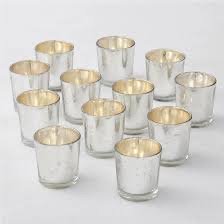 Several silver votive candle holders on a white background