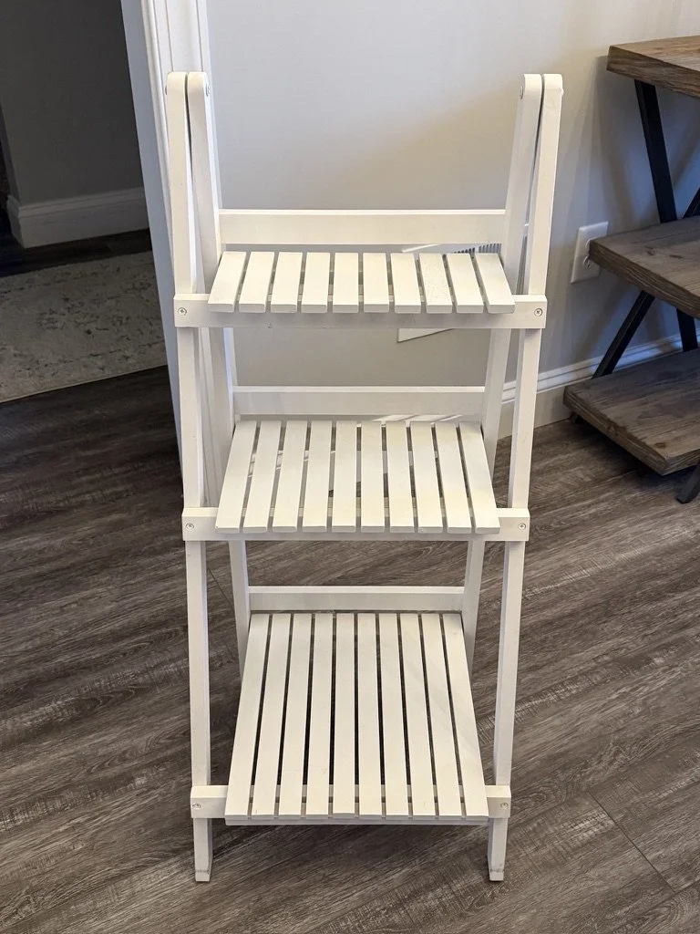 White wooden three-tier shelf on wooden floor