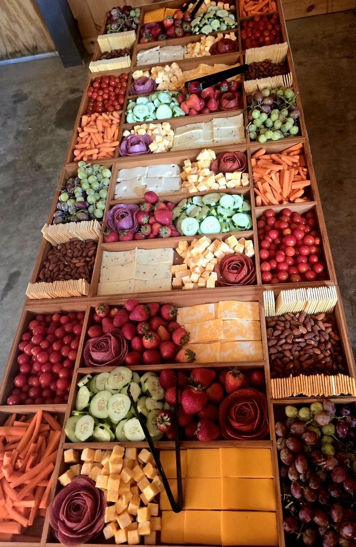 Charcuterie board with cheese, crackers, fruits, and vegetables