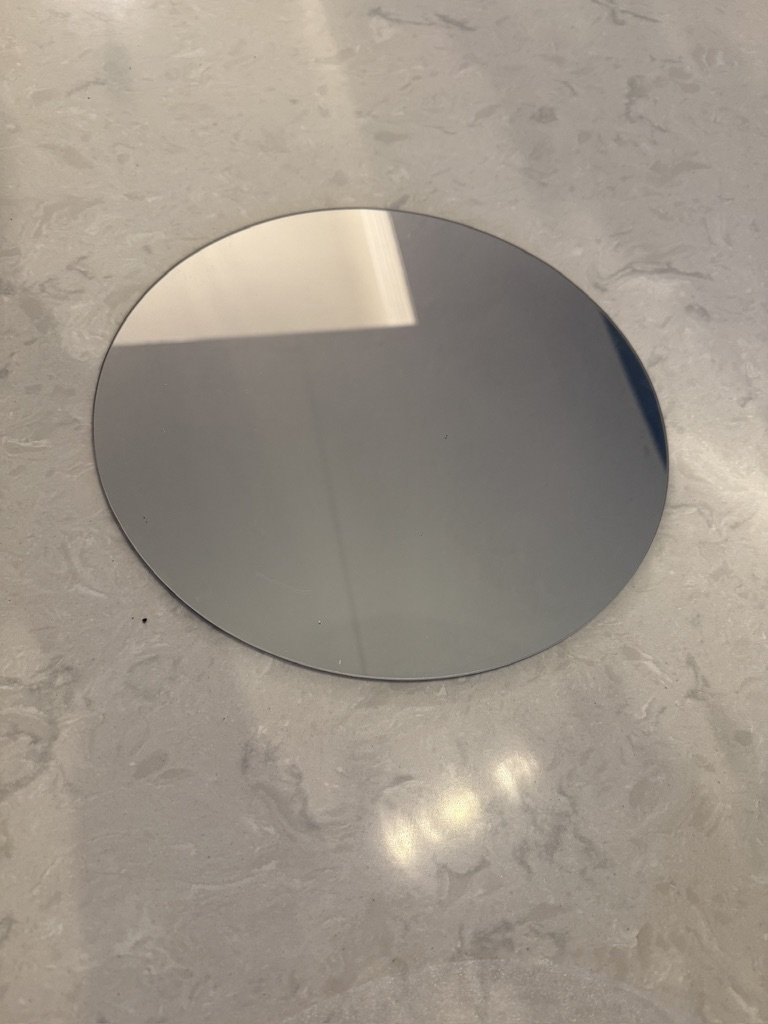 Round glass mirror on a marble surface