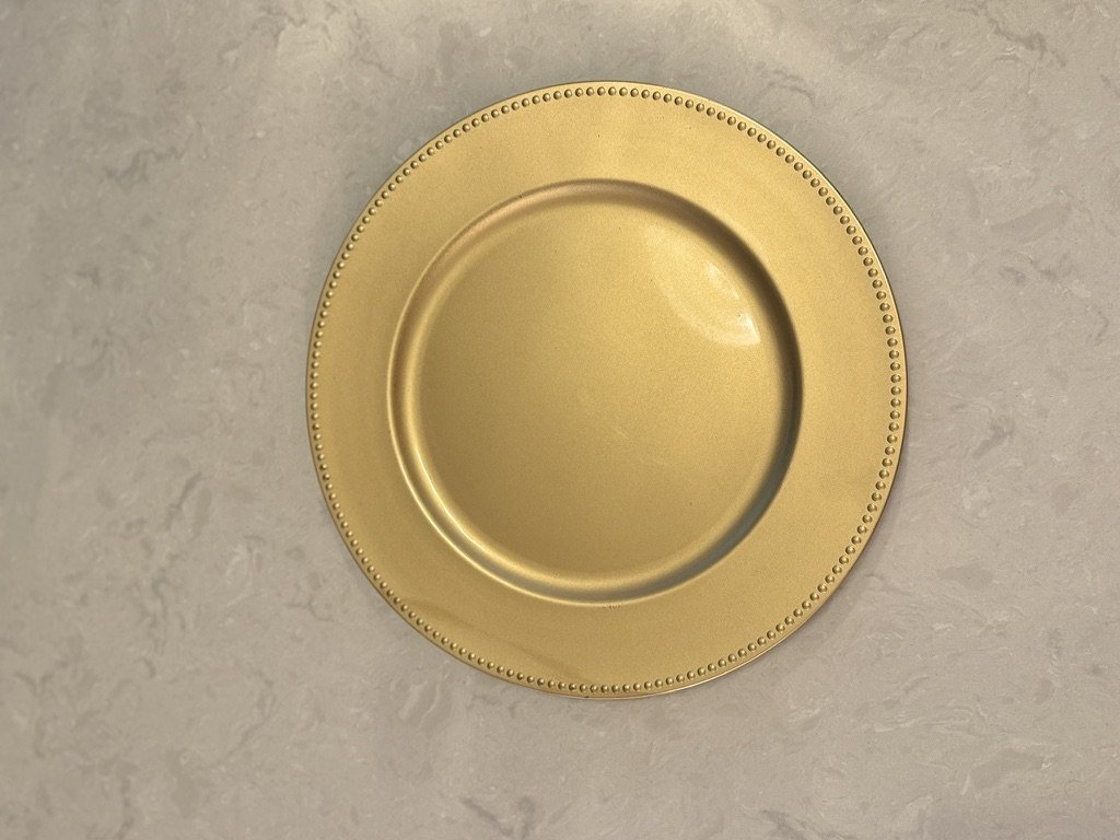 Golden decorative plate on marble surface