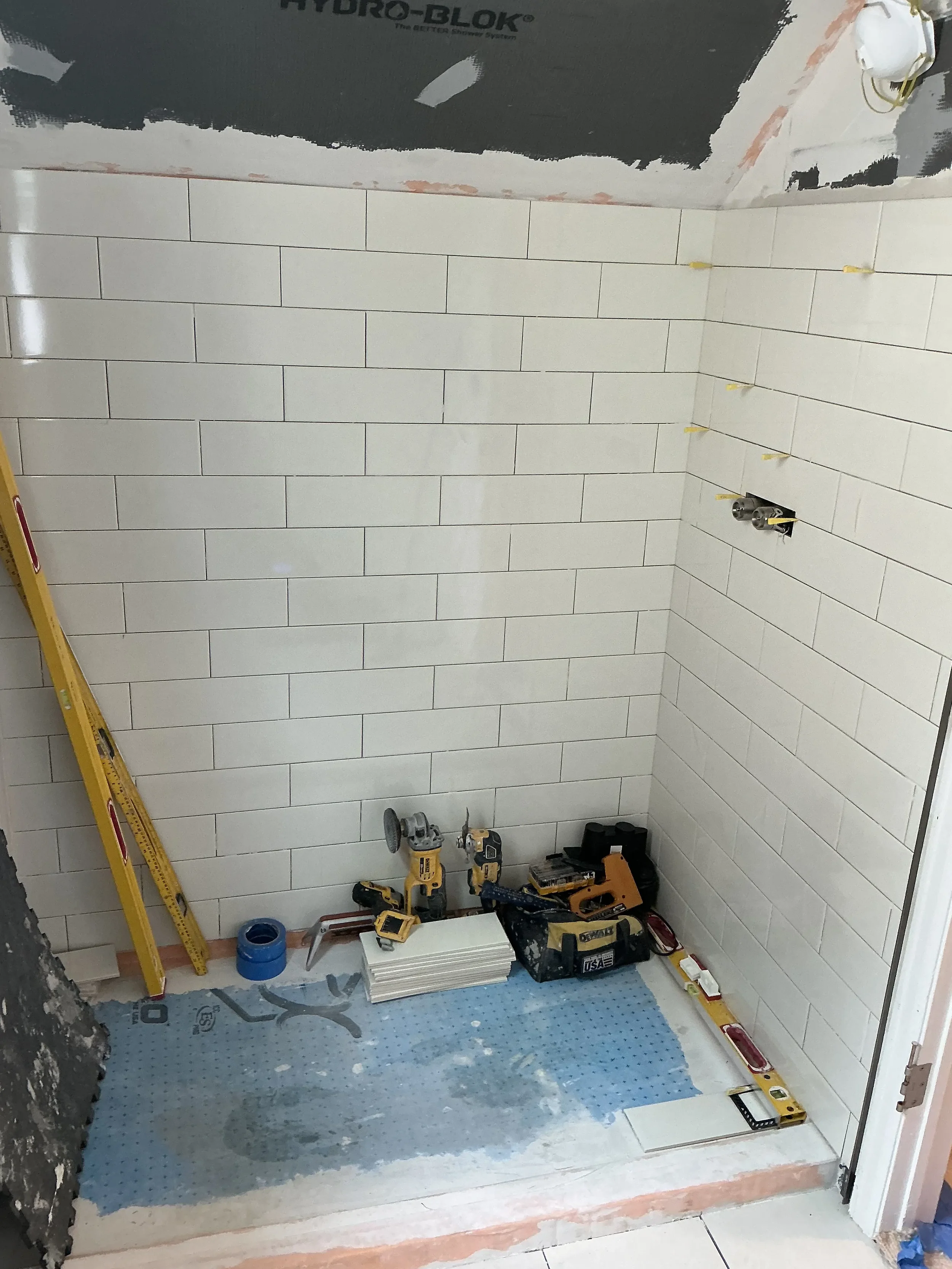 Bathroom in process of being remodeled in Boulder, CO by Downy Home Remodeling featuring new walk-in shower white subway tile install