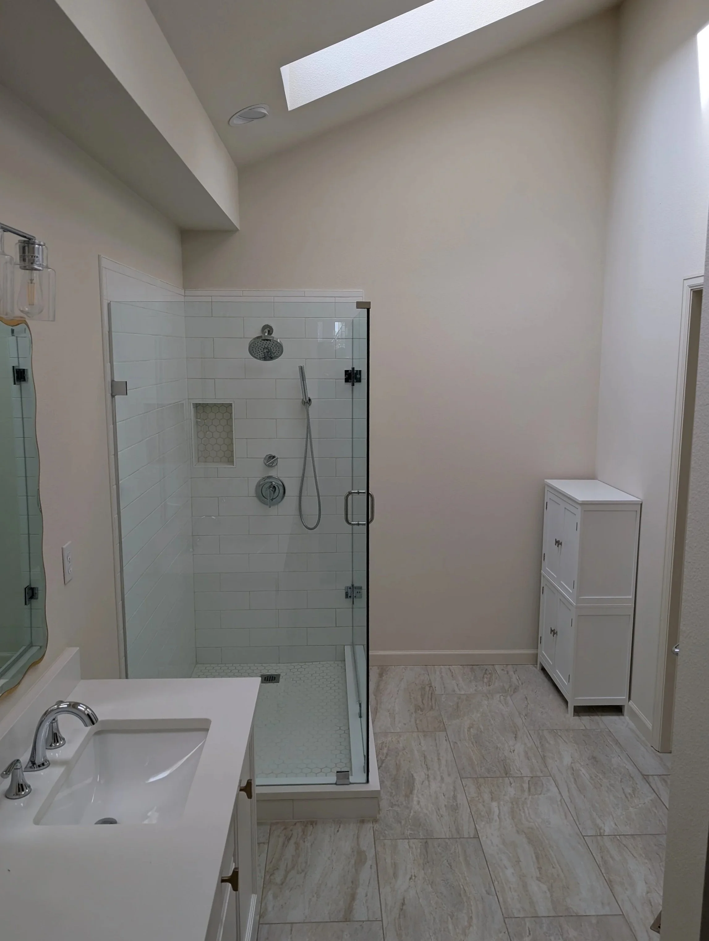 View of master bathroom in Gunbarrel, CO awaiting remodel with awkward layout, wasted space, small enclosed walk-in shower and simple white vanity