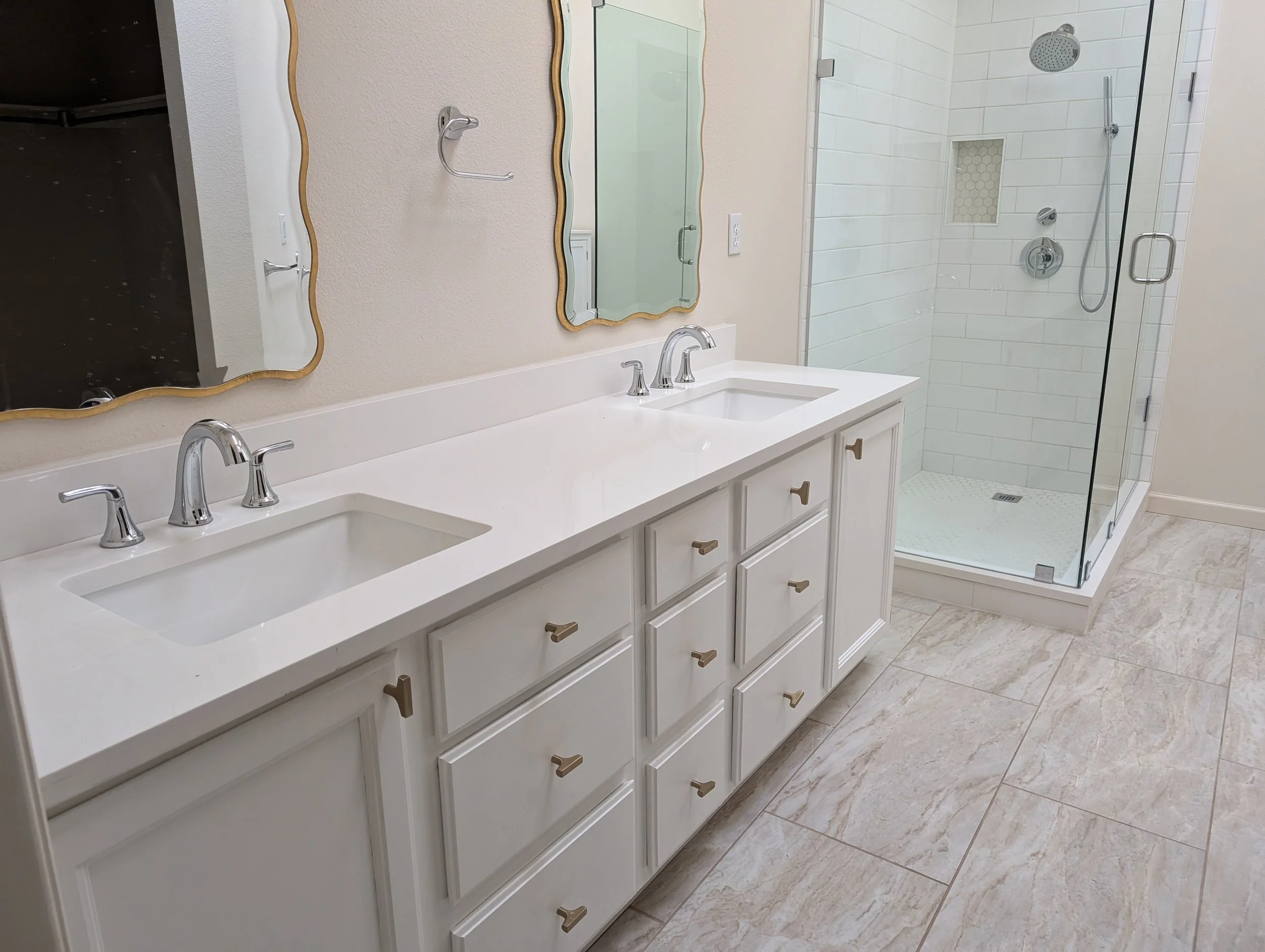 Gunbarrel, CO master bathroom remodel before pic, featuring plain white double vanity, glass walk-in shower with large gap between shower and vanity, and inefficient floorplan with wasted space.