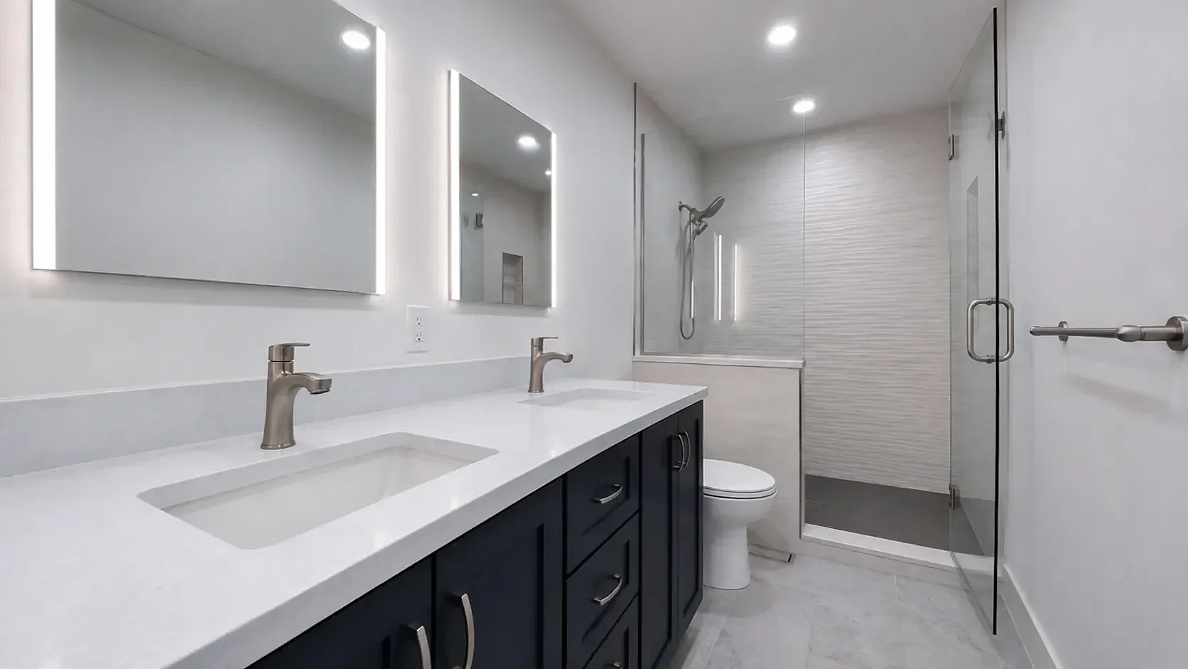 Overview of contemporary bathroom remodel in Table Mesa, Boulder, CO featuring double vanity with LED recessed cabinets and walk-in shower with textured large panel tile